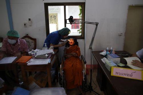 epa11399656 A dentist checks a Buddhist novice monk's teeth during a health check program at a Buddhist temple in Bangkok, Thailand, 09 June 2024. The Thai Public Health Ministry launched a health check program and healthcare campaign to the estimated 72,000 Buddhist monks across Thailand aimed to raise awareness of good health amid the growing concern of...