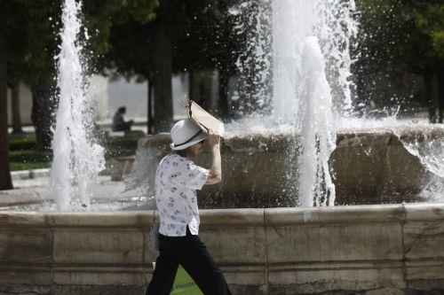 Μια γυναίκα περπατά μπροστά από το σιντριβάνι στην πλατεία Συντάγματος, κατά τη διάρκεια καύσωνα στο κέντρο της Αθήνας Πέμπτη 13 Ιουνίου 2024. Οι θερμοκρασίες σήμερα, σύμφωνα με την Εθνική Μετεωρολογική Υπηρεσία θα διατηρηθούν σε υψηλά επίπεδα και ως προς τις μέγιστες και ως προς τις ελάχιστες. Μικρή πτώση θα παρουσιάσει η θερμοκρασία μόνο στα βορειοδυτικά....