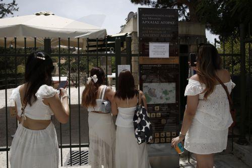Τουρίστες στέκονται έξω από τον κλειστό αρχαιολογικό χώρο της Αρχαίας Αγοράς έπειτα από την ανακοίνωση του Υπουργείου Πολιτισμού, με την οποία ενημερώνει για το κλείσιμο των αρχαιολογικών χώρων από 12.00 έως 17.00, λόγω υψηλών θερμοκρασιών, Αθήνα Πέμπτη 13 Ιουνίου 2024. Οι θερμοκρασίες σήμερα, σύμφωνα με την Εθνική Μετεωρολογική Υπηρεσία θα διατηρηθούν σε...