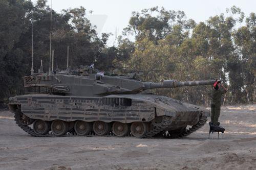 epa11408284 An Israeli soldier inspects the cannon of a tank at an undisclosed location near the border with the Gaza Strip, in southern Israel, 13 June 2024. The Israeli military stated on 13 June that its troops are continuing to operate against 'terrorist infrastructure and operatives' in the Gaza Strip. More than 37,000 Palestinians and over 1,400...