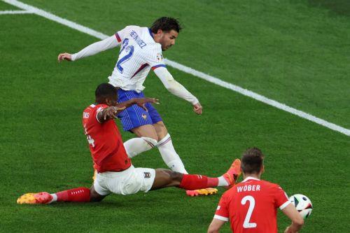 epa11418714 Theo Hernandez of France (top) in action against Kevin Danso of Austria during the UEFA EURO 2024 group D soccer match between Austria and France, in Dusseldorf, Germany, 17 June 2024.  EPA/GEORGI LICOVSKI