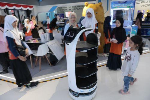 epa11435943 Visitors watch a robotic waiter moving around at a Robotic Park in Jakarta, Indonesia, 25 June 2024. The Indonesian government is encouraging progress in the field of robotics in the country in line with the rapid development of robotic technology supported by developments in artificial intelligence (AI). Indonesia has many educational...
