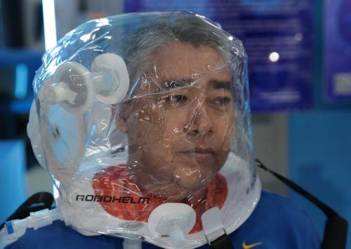 epa11435949 A visitor tries on  a robotic helmet from a medical device at a Robotic Park in Jakarta, Indonesia, 25 June 2024. The Indonesian government is encouraging progress in the field of robotics in the country in line with the rapid development of robotic technology supported by developments in artificial intelligence (AI). Indonesia has many...