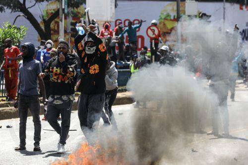epa11436100 Demonstrators react after setting a road barricade on fire during a protest against proposed tax hikes, in Nairobi, Kenya, 25 June 2024. Kenya's police on 25 June have sealed off the parliament and State House, and fired tear gas to disperse protesters demonstrating against planned tax hikes that many fear will worsen the cost-of-living crisis. ...