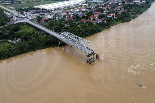 epa11594350 A handout photo made available by Vietnam News Agency shows an aerial view of the partially collapsed Phong Chau bridge into Red River, in Phu Tho province, northern Vietnam, 09 September 2024. According to state media, three people have been rescued and at least thirteen are missing following the collapse of the bridge into Red River on 09...