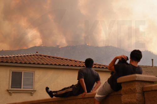 epaselect epa11597656 People watch the 'Airport Fire' burn in the distance in Lake Elsinore, California, USA, 10 September 2024. The quick-moving brush fire that ignited Monday afternoon in Orange County, before growing to more than 34,000 acres as of Tuesday night, according to Cal Fire, has triggered mandatory evacuations in both Orange and Riverside...
