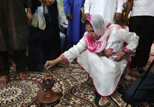epa11605328 A woman puts wild rue inside an Izband Soz, a Kashmiri traditional pot, during a mass marriage ceremony in Srinagar, the summer capital of Indian Kashmir, 15 September 2024. A total of 60 orphan girls and low-income couples got married during a mass ceremony organized by the non-governmental organization (NGO) 'J&K Al Noor Yateem Trust' to...