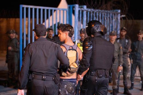 epa11608887 Moroccan police officers detain a man as they deploy to prevent illegal crossings near a customs checkpoint along the land border with the Spanish enclave of Ceuta, in Fnideq, northern Morocco, 16 September 2024. Hundreds of migrants on 15 September stormed a barbed wire fence to cross the land border from Fnideq to Ceuta, following a call on...