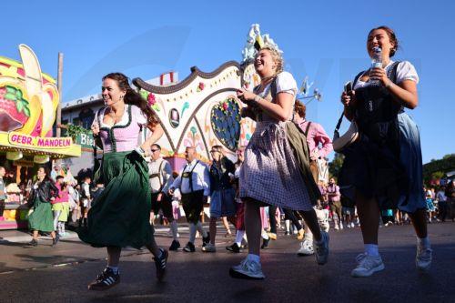 epa11616750 Visitors in traditional costumes run as the gates open for the 189th edition of the traditional Oktoberfest beer and amusement festival in the Bavarian capital Munich, Germany, 21 September 2024. According to its organizers, the Oktoberfest has grown into the world's largest folk festival, drawing around six million visitors annually. The...