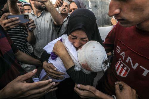 epa11658001 A Palestinian woman, grandmother of killed one-and-a-half-year old baby Yaman Al Zaneen, mourns while carrying his body during the funeral in Deir al Balah, central Gaza Strip, 14 October 2024. According to the Palestinian Ministry of Health, 23 people, including children, were killed after a school sheltering internally displaced Palestinians...