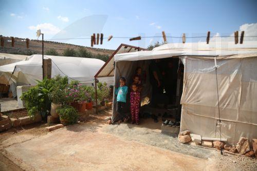 epa11659205 Displaced children stand inside a tent at a camp of Internally Displaced People (IDP) at Ma'arrat Misrin, Idlib, northwest Syria, 14 October 2024. Carden arrived in northwest Syria to inspect camps of displaced Syrians, the distribution of food aid provided by the WFP and meet with Syrians who fled the hostilities in Lebanon amid the conflict...