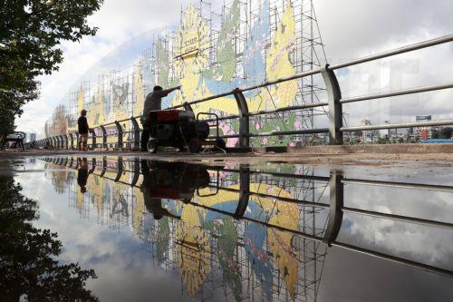 epaselect epa11667996 Cambodian workers install lights on a large boat in preparation for the annual Water Festival celebrations on the Tonle Sap River in Phnom Penh, Cambodia, 19 October 2024. The festival will see boat team from across Cambodia compete in races on the Mekong River. Water festival will run from 14 to 16 November 2024.  EPA/KITH SEREY