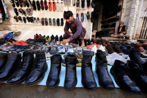 epa11679571 A man sells used winter shoes at a roadside market in Peshawar, Pakistan, 24 October 2024. People are increasingly turning to second hand markets for winter wear in response to rising inflation and declining purchasing power. While these markets are known for selling secondhand shoes, they also serve as a source of affordable winter wear across...