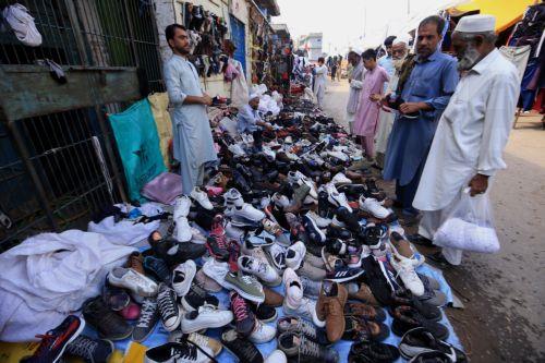 epa11679578 A man sells used winter shoes at a roadside market in Peshawar, Pakistan, 24 October 2024. People are increasingly turning to second hand markets for winter wear in response to rising inflation and declining purchasing power. While these markets are known for selling secondhand shoes, they also serve as a source of affordable winter wear across...