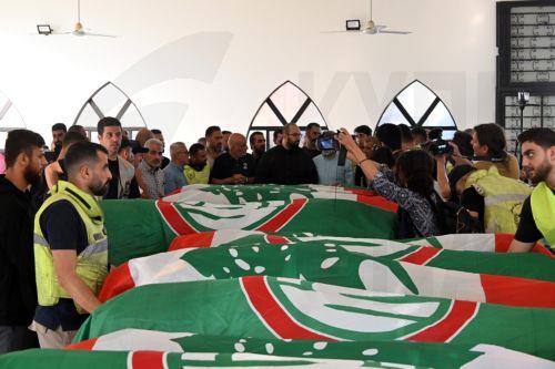 epa11707549 Mourners stand next to some of the coffins of 16 people who were killed in an Israeli strike in the town of Barja, during the funeral in the southern port city of Tyre, Lebanon, 07 November 2024. At least 20 people were killed as a result of an Israeli airstrike on a residential building in Barja late on 05 November, the Lebanese Ministry of...
