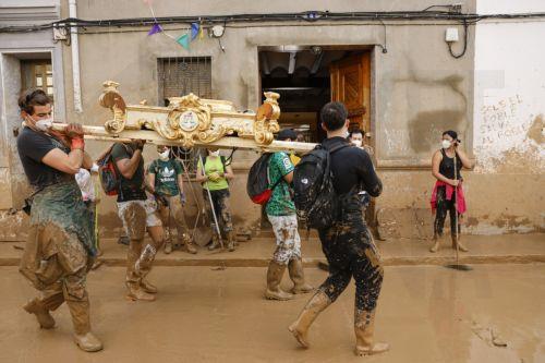 epa11707674 Volunteers carry the throne of a religious image during cleaning works in the flood-hit municipality of Masanasa, Valencia province, Spain, 07 November 2024. The devastating floods in Valencia and neighboring provinces have caused at least 219 fatalities, as efforts to search for missing people, provide supplies, and care for the victims...