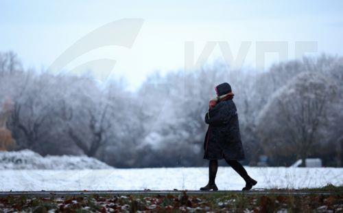 epa11728496 A person dressed in warm clothing walks through Sefton Park in Liverpool, Britain, 19 November 2024. The Met Office has issued yellow severe weather warnings for snow and ice across much of northern England, Scotland and Ireland as a low pressure system moves in from the Atlantic.  EPA/ADAM VAUGHAN