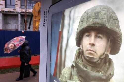 epa11733198 Pedestrians walk past a poster depicting a Russian soldier, in Moscow, Russia, 21 November 2024. On 24 February 2022, Russian troops entered Ukrainian territory in what the Russian president declared a special military operation, starting an armed conflict.  EPA/MAXIM SHIPENKOV