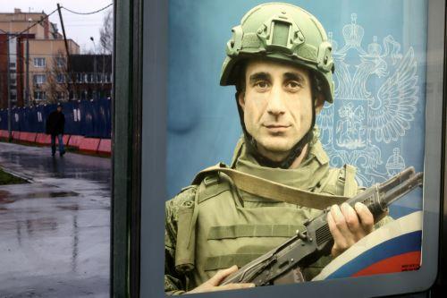 epa11733199 A pedestrian walks past a poster depicting a Russian soldier in Moscow, Russia, 21 November 2024. On 24 February 2022, Russian troops entered Ukrainian territory in what the Russian president declared a special military operation, starting an armed conflict.  EPA/MAXIM SHIPENKOV
