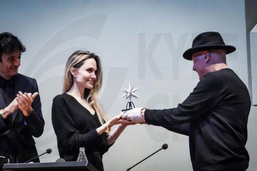 epa11738704 US actor Angelina Jolie (C), watched by festival director Giulio Base (L), receives the Stella della Mole Award from Italian writer Alessandro Baricco (R) at a press conference during the 42nd Torino Film Festival (TFF), in Turin, Italy, 24 November 2024. The film festival runs from 22 to 30 November 2024.  EPA/TINO ROMANO