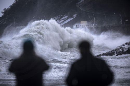 epa11764192 People look at big waves breaking on the coast in San Sebastian, Spain, 08 December 2024.  EPA/Javier Etxezarreta