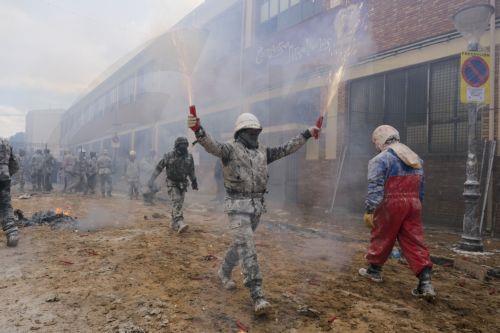 epa11795737 A man covered in flour holds firecrackers as people celebrate the traditional fest called 'The floured ones' (Els Enfarinats) in Ibi, Alicante, Valencia, Spain, 28 December 2024. The fest is celebrated during the 'Dia de los Santos Inocentes' (Saint Innocents Day), the Spanish version of April Fools' Day, and people battle among themselves with...
