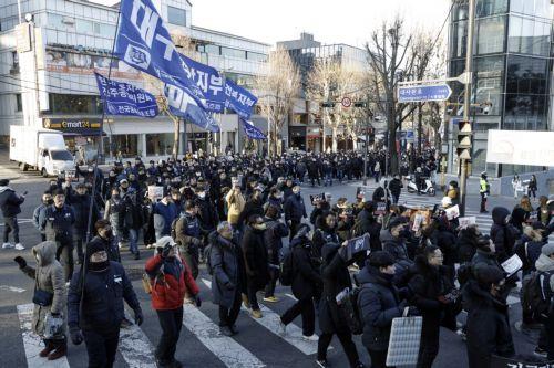 epa11803241 Members of the Korean Confederation of Trade Unions (KCTU) carry banners and flags as they march towards the presidential residence during a rally against impeached president Yoon, in Seoul, South Korea, 03 January 2025. A Seoul court on 31 December 2024 issued an arrest and search warrant to detain impeached president Yoon over his short-lived...