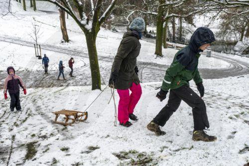 epa11806834 Children walk in the snow-covered Kronenburg Park during the first snowfall of the winter season in Nijmegen, Netherlands, 05 January 2025. Code yellow is in effect across the country for slipperiness due to snow and possible limited visibility.  EPA/MANON BRUININGA