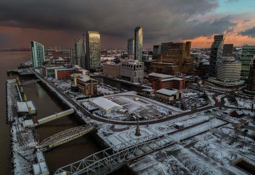 epa11810782 An aerial photograph taken by drone shows snow on the ground at the Pier Head in Liverpool, Britain, 07 January 2025. The Met Office has issued further yellow warnings for snow and ice across Northern Ireland and the west coast of Britain after heavy snowfall and rain caused widespread travel disruption and flooding.  EPA/ADAM VAUGHAN