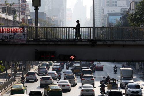 epa11825427 A pedestrian walks on a flyover as high rise buildings are shrouded by unhealthy levels of particle air pollution, during traffic congestion in Bangkok, Thailand, 15 January 2025. Thai authorities advised the public to wear face masks and avoid outdoor activities after the Thai capital of Bangkok and many parts of Thailand have been shrouded by...