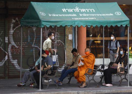 epa11825428 A Thai Buddhist monk and commuters wear face masks as a precaution against unhealthy levels of particle air pollution, in Bangkok, Thailand, 15 January 2025. Thai authorities advised the public to wear face masks and avoid outdoor activities after the Thai capital of Bangkok and many parts of Thailand have been shrouded by fine particulates...