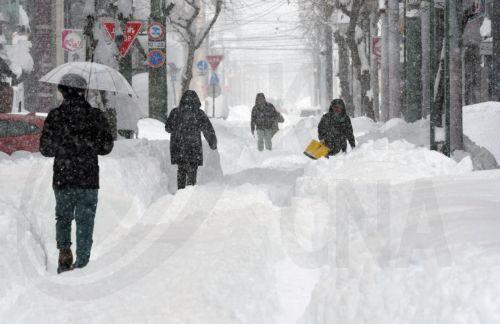 epa11875694 People walk in a street covered with snow following heavy snowfall in Obihiro, Hokkaido, northern Japan, 04 February 2025 (issued 05 February 2025). On 05 February 2025, the coldest air of the winter persisted over the Japanese archipelago, bringing heavy snowfall to Hokkaido and areas along the Sea of Japan coast. The cold front is expected to...