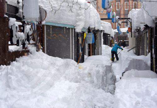 epa11875695 A man digs snow following heavy snowfall in Obihiro, Hokkaido, northern Japan, 04 February 2025 (issued 05 February 2025). On 05 February 2025, the coldest air of the winter persisted over the Japanese archipelago, bringing heavy snowfall to Hokkaido and areas along the Sea of Japan coast. The cold front is expected to continue for several days,...
