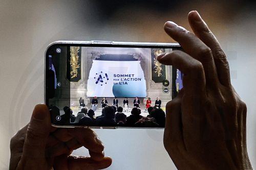 epa11888559 A participant takes a photograph with a smartphone during a plenary session of the Artificial Intelligence (AI) Action Summit at the Grand Palais in Paris, France, 11 February 2025. The summit takes place from 10 to 11 February.  EPA/MOHAMMED BADRA