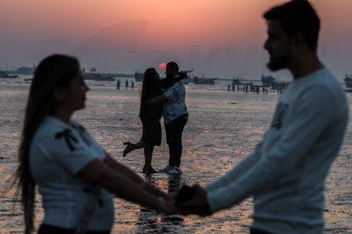 epa11896029 Couples pose for a photo as they celebrate Valentine's Day at Gorai Beach near the Arabian Sea shore in Mumbai, India, 14 February 2025. Valentine's Day annually falls on 14 February and is considered in many countries as the feast of lovers.  EPA/DIVYAKANT SOLANKI