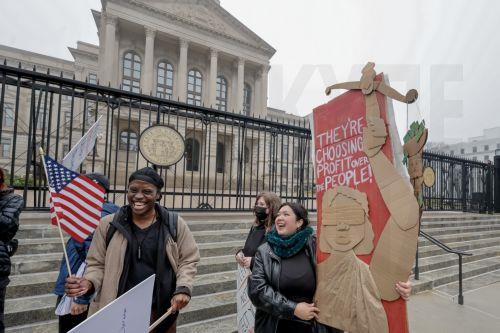 epa11899493 Demonstrators participate in a democracy protest against recent Trump administration policies and actions outside the Georgia State Capitol in downtown Atlanta, Georgia, USA, 15 February 2025. The small group marched and chanted against US President Trump, Elon Musk, government worker firings, and mass immigration deportations.  EPA/ERIK S....
