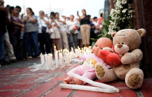 epa11920086 Candles and flowers are displayed during a vigil for the people who died after part of the roof of Trujillo's Real Plaza shopping mall collapsed in Trujillo, Peru, 23 February 2025. The families of the victims who died demanded justice for the eight deaths and dozens of injuries while rescue work continues.  EPA/STEFFANO PALOMINO