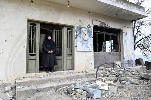 epa11947123 Zainab Nasrallah, 53, stands at the entrance of her house, which was destroyed by Israeli forces ahead of International Women's Day celebrations in the southern Lebanese village of Houla, Lebanon, 07 March 2025. Nasrallah remained in her village for nine months during the fighting between Hezbollah and Israeli forces before moving to a nearby...
