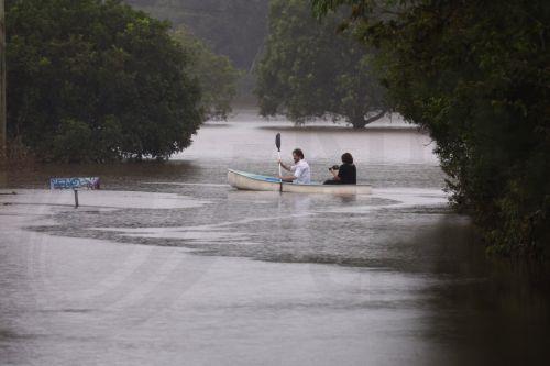 epa11953149 Local residents paddle a canoe down a street in South Lismore, New South Wales, Australia, 10 March 2025. Cyclone Alfred has been downgraded to a tropical low but its impact is still being felt with a region reeling from major flooding with more wild weather forecast.  EPA/JASON O'BRIEN AUSTRALIA AND NEW ZEALAND OUT