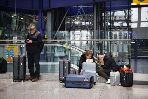 epa11977858 Passengers wait at Heathrow Airport in London, Britain, 21 March 2025. The Heathrow Airport on 21 March announced it would be closed all day, following a power outage 'due to a fire at an electrical substation supplying the airport'.  EPA/TOLGA AKMEN
