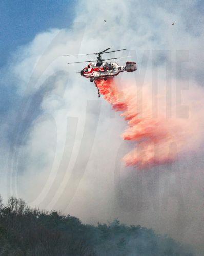 epa11984936 A Korea Forest Service helicopter dumps fire retardant on a wildfire in Uiseong, North Gyeongsang Province, South Korea, 24 March 2025, as it burns for the fourth consecutive day.  EPA/YONHAP SOUTH KOREA OUT