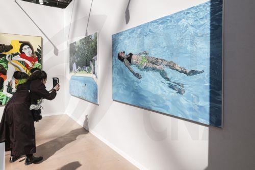 epa12004918 A woman takes a picture of the painting Felicity by French artist Adrien Belgrand, displayed at the French gallery Lara Sebdon stand during the Art Paris fair at the Grand Palais in Paris, France, 02 April 2025. The modern and contemporary fair Art Paris runs from 03 to 06 April 2025 and hosts 170 galleries from 25 countries around the world. ...
