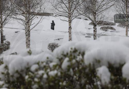 epa12020140 A woman walks in a park after a snowfall in Moscow, Russia, 09 April 2025. Huge snowfall and low temperatures up to minus nine Celsius degrees hit Moscow during the week after a normal warm and snowless winter. The thickness of the snow cover in Moscow is 20 centimeters, and in the Moscow region it reaches 30 cm.  EPA/SERGEI ILNITSKY