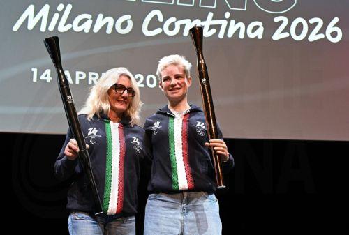 epa12031395 Former Italy cross-country skier Stefania Belmondo (L) and Paralympic champion Beatrice 'Bebe' Vio (R) hold the Milano-Cortina 2026 Winter Olympics and Paralympics torches during the unveiling ceremony in Milan, Italy, 14 April 2025.  EPA/DANIEL DAL ZENNARO