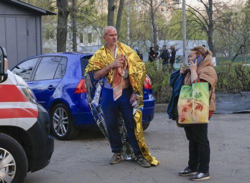 epaselect epa12038479 People stand at the site of a rocket attack near a high-rise building in a residential area in Kharkiv, Ukraine, 18 April 2025, amid the ongoing Russian invasion. At least one person died, and more than 80 others were injured, including six children, according to the State Emergency Service.  EPA/SERGEY KOZLOV