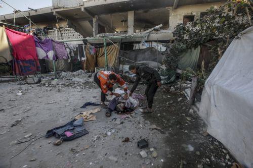 epa12054655 GRAPHIC CONTENT - Palestinians inspect the body of a man following an Israeli airstrike, at Al Farabi school in Gaza City, northern Gaza Strip, 25 April 2025. According to the Palestinian Ministry of Health in Gaza, at least three Palestinians were killed and 10 others wounded in Israeli airstrikes.  EPA/MOHAMMED SABER -- ATTENTION EDITORS:...