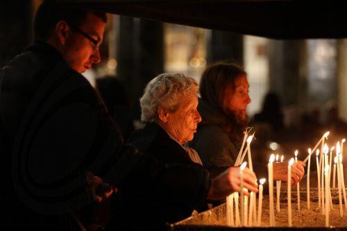 epa12054769 Catholic faithful light candles during a Holy Mass in honor of late Pope Francis at St Dionysius Cathedral in Athens, Greece, 25 April 2025. Pope Francis died on 21 April 2025 at the age of 88, according to the Holy See.  EPA/ORESTIS PANAGIOTOU