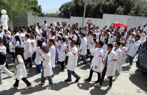 epa12069263 Young Tunisian doctors take part in a demonstration to demand better working conditions, in front of the Ministry of Health in Tunis, Tunisia, 02 May 2025. The Tunisian Organization of Young Doctors organized a national strike and a march from the Faculty of Medicine in Tunis towards the Ministry of Health to demand better working conditions in...