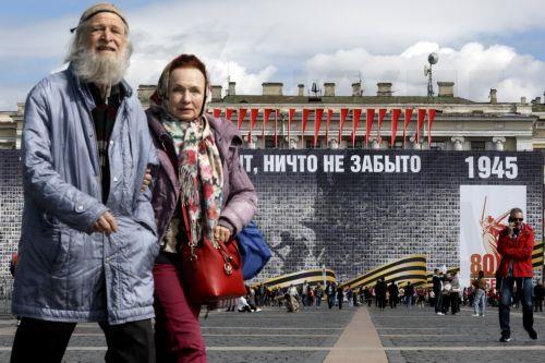 epa12069329 People walk on the Dvortsovaya (Palace) Square decorated with a panel depicting images of Russian veterans and reading 'No one is forgotten, nothing is forgotten', ahead of the Victory Day celebrations in St. Petersburg, Russia, 02 May 2025. Russia will mark on 09 May the 80th anniversary of the victory of the Soviet Union over Nazi Germany and...