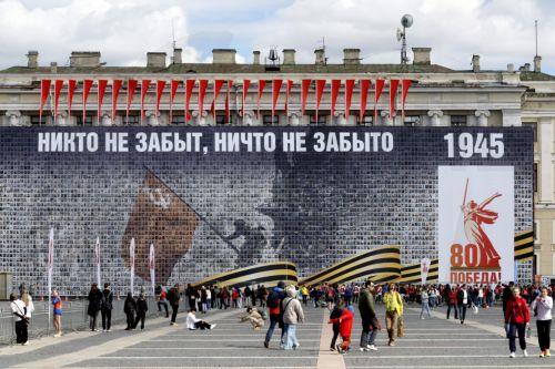 epa12069333 People walk on the Dvortsovaya (Palace) Square decorated with a panel depicting images of Russian veterans and reading 'No one is forgotten, nothing is forgotten', ahead of the Victory Day celebrations in St. Petersburg, Russia, 02 May 2025. Russia will mark on 09 May the 80th anniversary of the victory of the Soviet Union over Nazi Germany and...